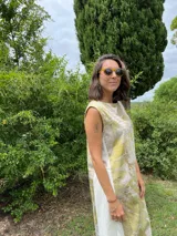 Vestido midi de corte evasé con estampado de hojas en tonos verdes y beige.