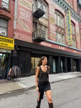 Minifalda ajustada de tejido de punto color marrón oscuro, con detalle de lazo o nudo en el lateral.