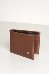 Billetera de hombre plegable confeccionada en cuero texturizado color tostado, con costuras a la vista en hilo claro y detalle de logo metálico circular en el frente. El interior presenta un contraste en color negro y múltiples ranuras para tarjetas.