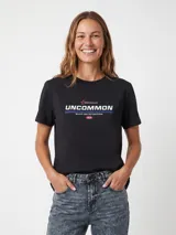 Remera negra de manga corta y cuello redondo, con estampa frontal geométrica y texto "UNCOMMON".