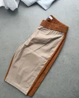 Short tipo biker confeccionado en cuerina de color nude en la parte frontal y trasera, con laterales de pana en tono tostado y cintura elástica en pana a juego.