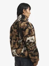 Campera tipo pullover de Carhartt WIP confeccionada en fleece texturado con estampado animal print abstracto en tonos marrón, negro y blanco. Presenta cuello alto con cierre frontal de botones a presión, bolsillo tipo canguro y detalles en tafeta de nylon.