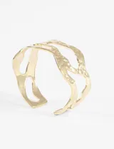 Pulsera rígida de acero quirúrgico con diseño irregular y calado, de acabado brillante.