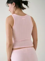 Musculosa básica entallada de tela pointelle color blanco, con escote redondo y detalle de ondas en los bordes.