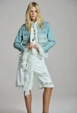 Chaqueta de jean estilo militar con alamares y botones metálicos decorativos en la parte frontal y las mangas.