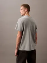 Remera gris de algodón con logo Calvin Klein Jeans estampado en rojo en el pecho.