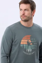 Remera de manga larga y cuello redondo en color verde militar, con estampa frontal circular de temática de montaña y escalada en tonos naranja, amarillo y turquesa. Incluye el texto "Life is better with mountain climbing" y la marca "Legacy-Original Brand".