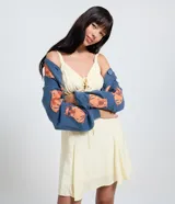 Vestido corto evasê de viscosa en color amarillo con estampado de cuadros vichy. Cuenta con escote en V, fruncido bajo el busto, lazo central y tirantes regulables.