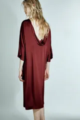 Vestido midi de Zara Woman Collection confeccionado en viscosa satinada, color bordó. Presenta cuello barco, mangas por debajo del codo y bajo recto, con detalle de lazo fino en la parte posterior del cuello.