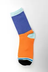 Pack de tres pares de medias estilo crew con diseños geométricos y combinaciones de colores celestes, azules, naranjas y blancos.