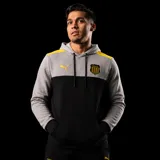 Buzo con capucha Puma del Club Atlético Peñarol. Diseño de bloques de color con parte superior gris y parte inferior negra, detalles en amarillo en los hombros, logo de Puma y escudo del club bordados en el pecho.