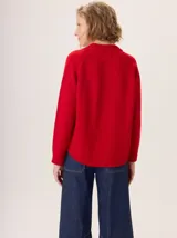 Sweater de punto color rojo, con mangas largas ranglán, cuello redondo acanalado y dobladillo redondeado.