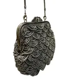 Bolso de mano estilo vintage, completamente bordado con mostacillas en tono peltre formando un patrón de escamas. Presenta una boquilla metálica dorada con cierre a presión y una cadena metálica a tono para llevar al hombro.