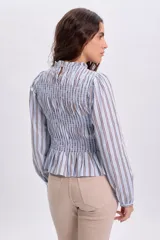 Blusa celeste a rayas marrones y blancas, con diseño de punto smock en el pecho y mangas largas abullonadas con puños elásticos.