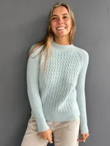 Sweater de punto con textura suave, color celeste, con diseño de ochos en el frente y tejido morley en mangas y espalda. Presenta cuello redondo a la base y mangas largas.