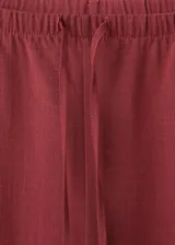Pantalón largo de corte recto y holgado color bordó, con cintura ajustable mediante elástico y lazo, y bolsillos laterales.