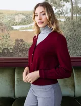 Cardigan rojo tejido en hilado fino, con escote en V y abertura central con botones metálicos.