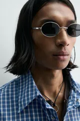 Camisa de manga larga con cuello solapa y bolsillo plastrón en el pecho. Presenta un estampado de cuadros pequeños en tonos azul y blanco. Cierre frontal con botones a presión.