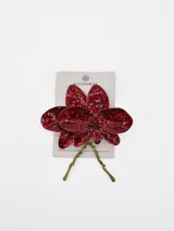 Aros colgantes en forma de flor roja con textura brillante y detalles de tallos dorados.