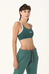 Top deportivo verde con breteles blancos y logo de la marca en el frente.