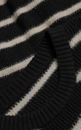 Sweater de cuello redondo con diseño de rayas horizontales en blanco y negro. Confeccionado en tejido de punto con textura suave, corte oversize y terminaciones en punto rib en cuello, puños y ruedo.