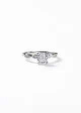 Anillo de plata 925 con diseño de banda entrelazada tipo infinito, engastado con una zirconia central de corte redondo y pequeñas zirconias en los laterales.