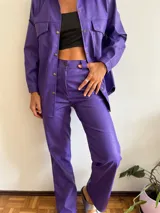 Pantalón lila de cuero sintético con estampado croco, corte recto y tiro alto.