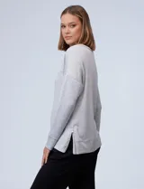 Buzo de cuello redondo y manga larga, confeccionado en tejido modal gris melange. Presenta un corte recto con costura horizontal en el pecho y puños ajustados.