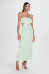Vestido midi color menta de crepé de acetato, con escote recto, tirantes finos y recortes cut-out en la cintura. Presenta bordados hechos a mano con pedrería en la parte delantera y falda recta.