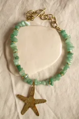 Collar con cuentas de piedra verde y dije de estrella de mar de bronce.