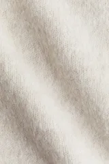 Buzo de punto suave con lana, de corte entallado, cuello camisero, tapeta con botones y terminaciones acanaladas en puños y bajo.