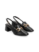 Zapato tipo mule con taco cuadrado forrado, punta cuadrada y detalle de ornamento metálico dorado en el empeine. Presenta diseño destalonado con tira ajustable mediante hebilla lateral.