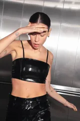 Top corto negro de charol con escote recto y espalda con cierre desmontable central.