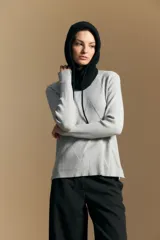 Polera de cuello alto en color blanco, confeccionada en tejido acanalado con un diseño geométrico de relieve que crea un efecto visual estilizado. Presenta un corte al cuerpo y mangas largas, ideal para usar como prenda base o principal.