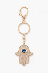 Llavero dorado con dije de mano de Fátima (Hamsa) decorado con cristales brillantes y un ojo turco central.