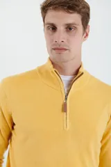 Sweater verde oliva de tejido acrílico con textura similar al cashmere, corte clásico, cuello alto con cierre metálico y tirador de cuerina ecológica.