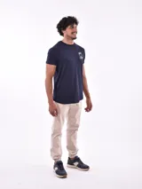 Remera blanca de manga corta con cuello redondo y un pequeño logo estampado en color verde menta en el pecho.