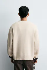 Jersey de corte relajado confeccionado en tejido de algodón. Presenta cuello redondo, manga larga y acabados en rib en puños, cuello y bajo.