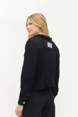 Campera de jean negra con cuello mao y volados, cierre frontal con botones metálicos y bolsillos de parche en el pecho.