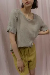 Short blanco de calce relajado con cintura elástica y lazo regulable. Presenta bolsillos amplios con ribete interior de color naranja neón.