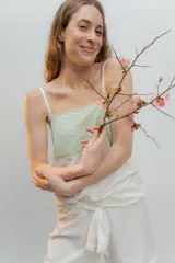 Pijama de dos piezas, compuesto por una musculosa blanca con detalle de puntilla negra elástica en el escote y un short blanco con elástico y lazo negro en la cintura.