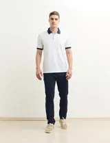 Remera manga corta color verde con cuello polo y bolsillo en el pecho. El cuello y los puños son de color azul marino.