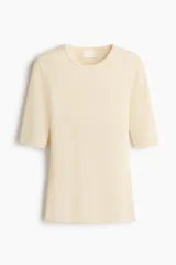 Remera de punto acanalado fino color beige, entallada al cuerpo, con cuello redondo ribeteado y mangas al codo.
