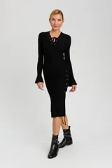 Falda midi negra de tejido de punto acanalado, con silueta ajustada, bajo acampanado y detalle de lazos entrecruzados en el lateral.