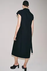Vestido midi camisero de algodón color negro, con cuello solapa, sin mangas y cierre frontal con botones ocultos por solapa. Incluye cintura ajustable con tiras de lazada lateral en el mismo tejido.