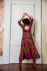 Vestido largo con estampado abstracto en tonos burdeos, verde y gris. Tiene mangas largas acampanadas y escote redondo.