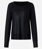 Blusa de punto color dorado, de acrílico y viscosa, con escote redondo, manga larga y sisa raglán. Tiene una malla con lámina metálica.