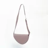 Bandolera de diseño semicircular en color rosa, con correa larga ajustable y cierre superior.