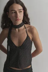 Top halter negro con lunares blancos, de tela tipo gasa, para atar al cuello y con espalda descubierta. Incluye corbatín.