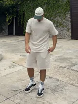 Conjunto de dos piezas compuesto por remera de manga corta y short, confeccionado en tejido de punto calado con textura tipo waffle. La remera presenta cuello redondo y corte holgado, mientras que el short cuenta con cintura elástica.